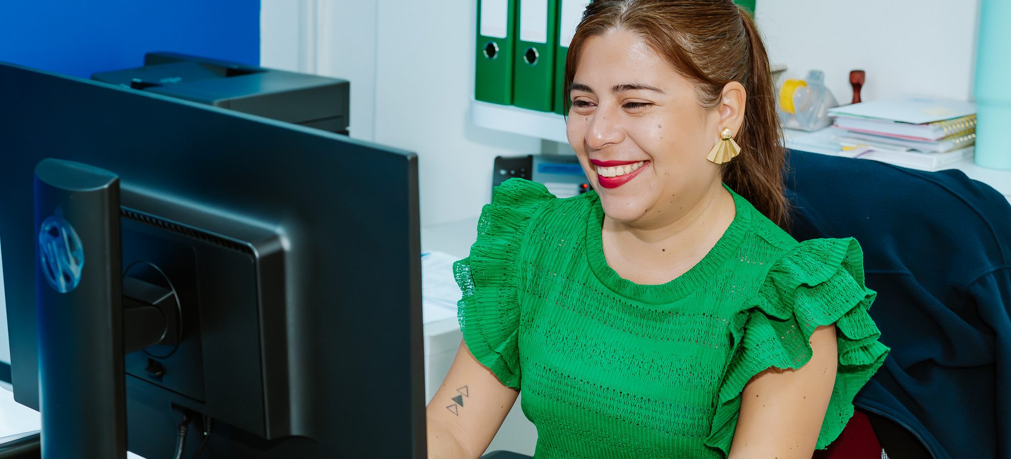 Post Aruba customer service agent smiling at her desk