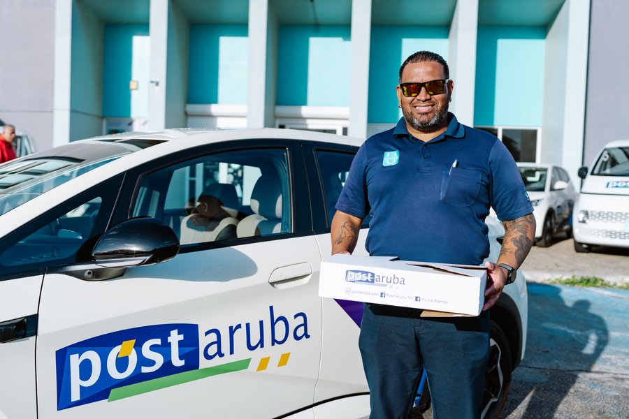 Post Aruba courier delivering a parcel to a client by car